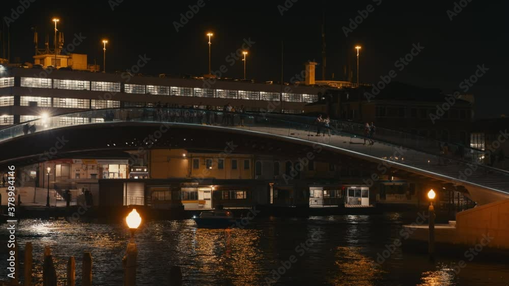 Constitution Bridge in the City of Venice at night with boat on the water and city lights Constitution Bridge in the City of Venice at night with boat on the water and city lights