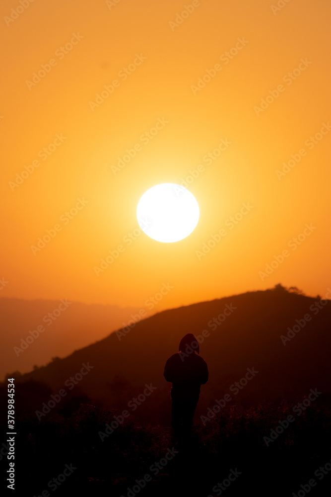 Man is standing and watching sunset at Mountainside. silhouette Man is standing and watching sunset at Mountainside. silhouette