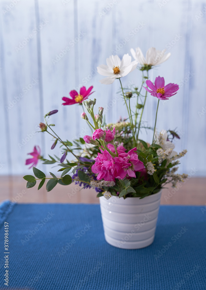 custom made wallpaper toronto digitalmulticolored wildflowers stand on a wooden table, on a blue cloth napkin, in a white vase against a blue wall