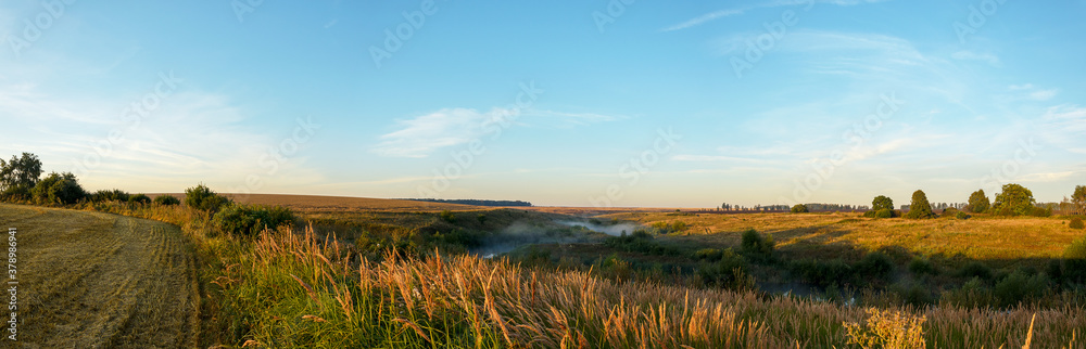Summer landscape with golden fields and small calm river during sunrise. Summer landscape with golden fields and small calm river during sunrise.