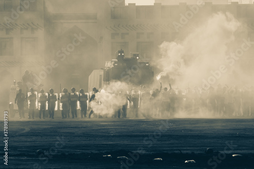 Military police riot response to a protest with tear gas, smoke, fire, explosions. Political expression, riot, protest, demostration and military concept. photo