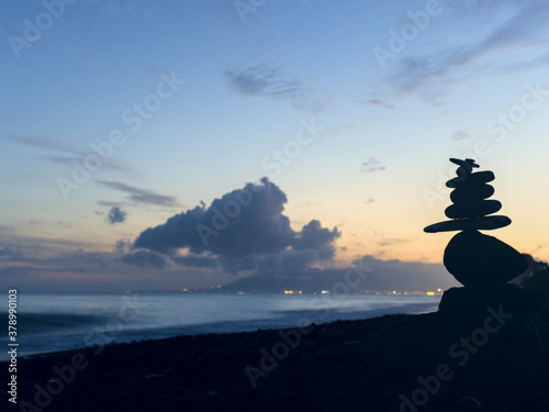 Close up of a pile of stones in the beach at sunset with blurr background. Zen & Spa Concept.