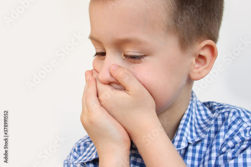 crying child, kid, covering his mouth with fear, shame or resentment, cry and afraid, concept of abuse, outsider in the children’s team, bullying, family violence