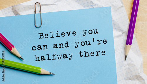 Believe you can and you're halfway there text written on a paper with pencils in office photo