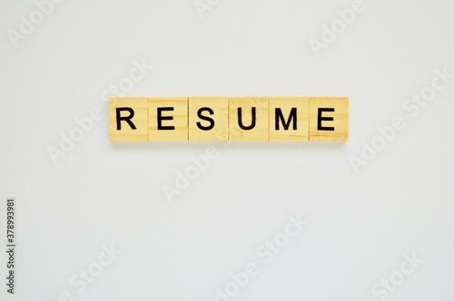 Word resume. Wooden blocks with lettering on top of white background. Top view of wooden blocks with letters on white surface