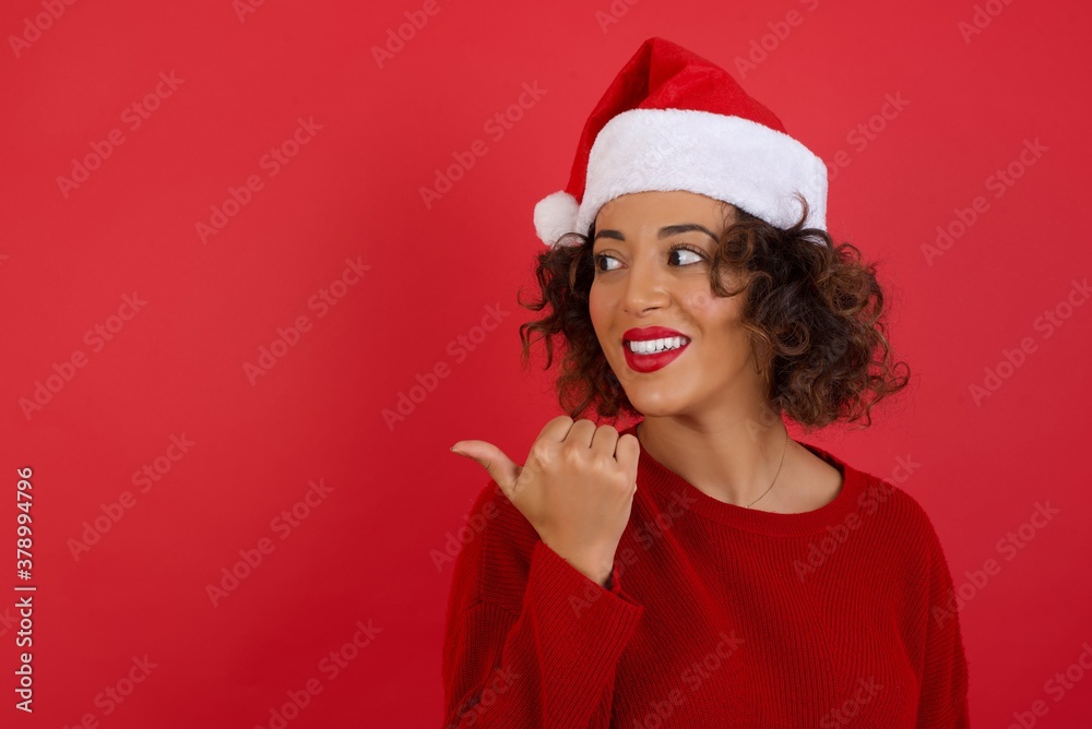 Omg concept. Stupefied caucasian female with surprised expression, opens eyes and mouth widely, points aside with thumb, shows something strange on gray background. Advertisement concept. Omg concept. Stupefied caucasian female with surprised expression, opens eyes and mouth widely, points aside with thumb, shows something strange on gray background. Advertisement concept.
