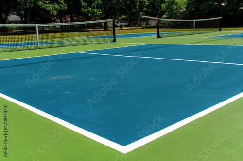 Recreational sport of pickleball court in Michigan, USA looking at an empty blue and green new court at a outdoor park. Ground View. © KingmaPhotos
