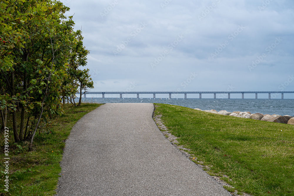 A pathway in an area for leisure activities. The Oresund Bridge, Malmo, southern Sweden in the background A pathway in an area for leisure activities. The Oresund Bridge, Malmo, southern Sweden in the background