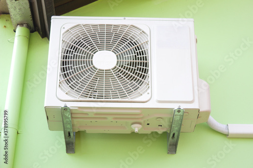 External air conditioning machine placed on the wall of a house photo