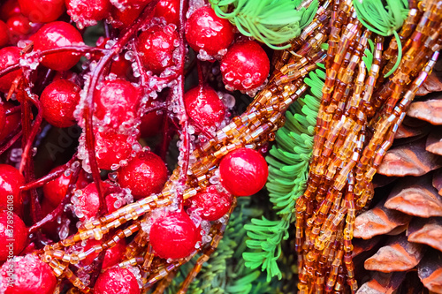 Christmas decoration background close-up. Festive beads, red berries, cedar cone