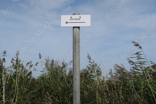 Schild mit der Aufschrift "Zum Strand" in den Salzwiesen der Nordseeinsel Langeoog