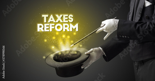 Illusionist is showing magic trick with TAXES REFORM inscription, new business model concept