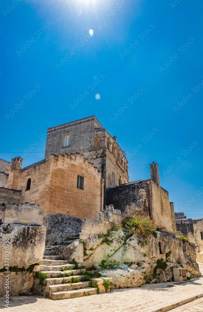 Matera, Basilicata, Italy - A glimpse of the ancient city, with the typical stone and brick houses of the old town of Matera, in the Sasso Caveoso and Barisano. A stone staircase.