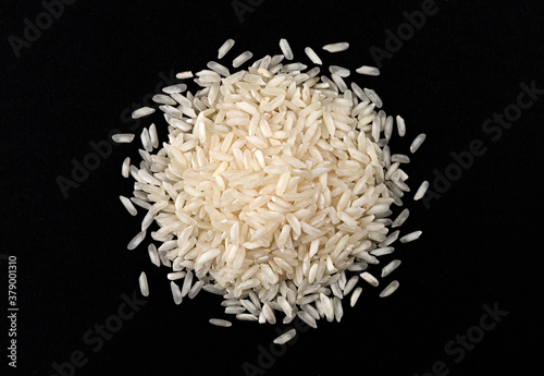 Heap of risotto rice isolated on black background