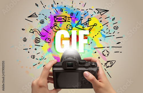 Close-up of a hand holding digital camera with abstract drawing and GIF inscription photo