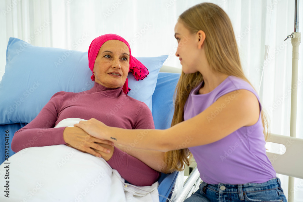 Fototapeta premium Caucasian senior woman with breast cancer patient lying on hospital bed with young european daughter supporting 