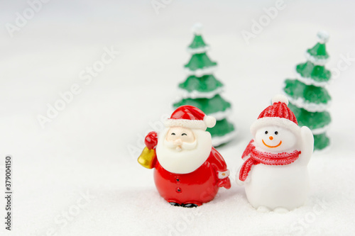 Merry Christmas and happy new year concept. Cute santa claus figure and tree on snow with copy space