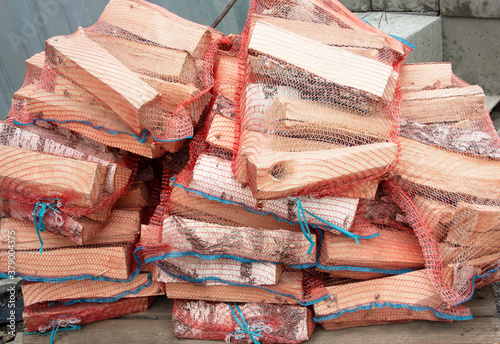 Stack of birch firewood packed in a net for sale