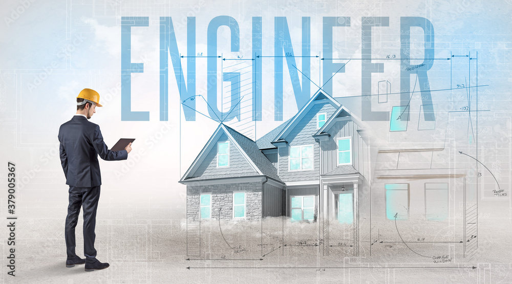 Young engineer holding blueprint with ENGINEER inscription, house planning concept Young engineer holding blueprint with ENGINEER inscription, house planning concept