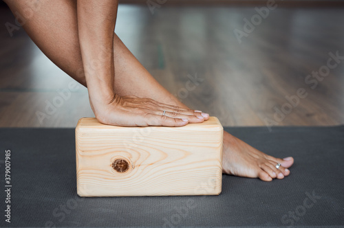 Extended triangle pose with brick  closeup, utthita trikonasana pose using wooden block in yoga iyengar