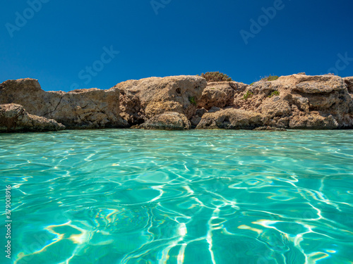 Elafonisi Crete Beach view to crystal clear water with nature rocks at the background