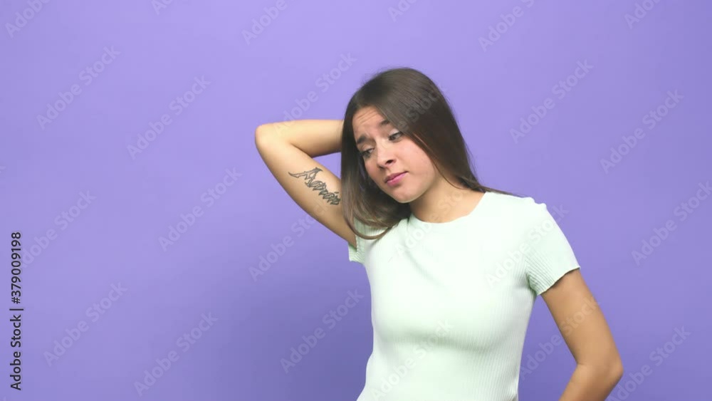 Young cute woman touching back of head, thinking and making a choice Young cute woman touching back of head, thinking and making a choice