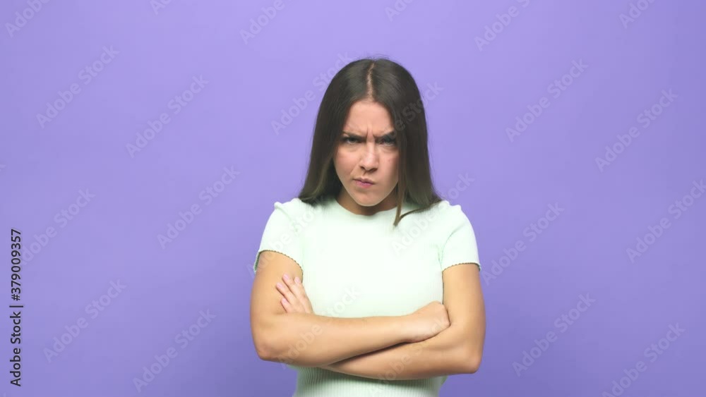 Young cute woman frowning face in displeasure, keeps arms folded Young cute woman frowning face in displeasure, keeps arms folded