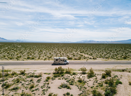 Aerial view of a motorhome driving on a highway in the desert of USA California