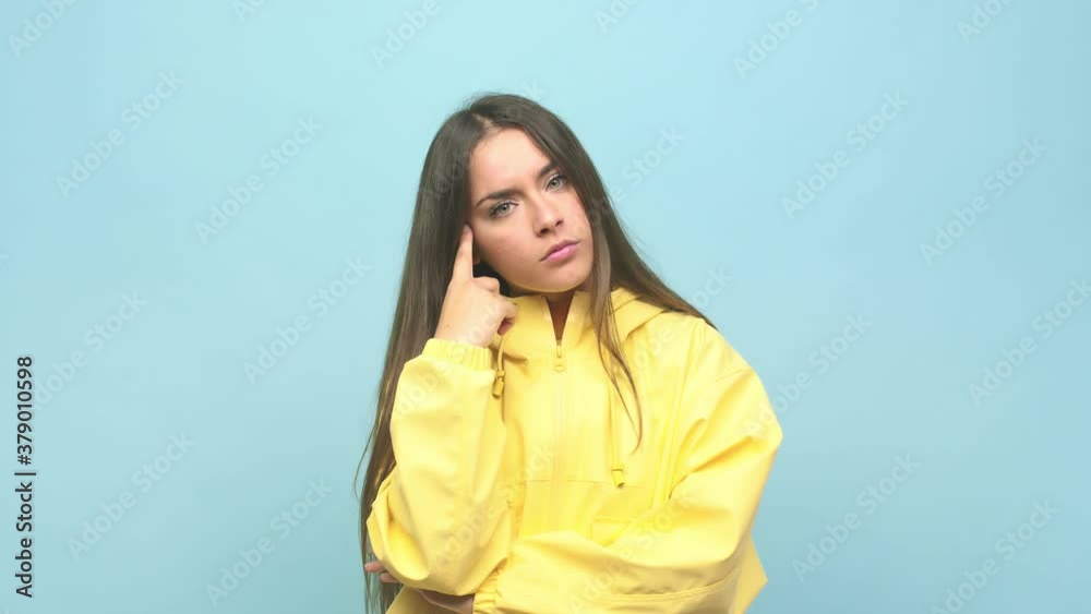 Young cute woman pointing temple with finger, thinking, focused on a task Young cute woman pointing temple with finger, thinking, focused on a task