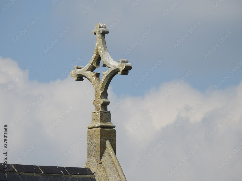 A stone cross on a background of clouds