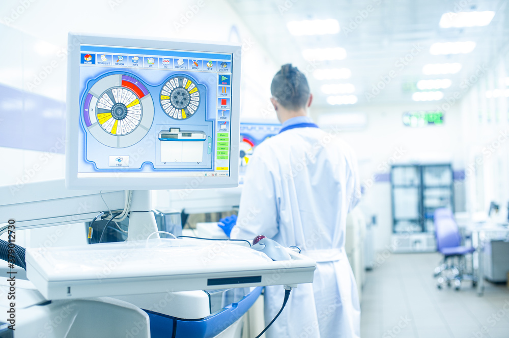 Obraz premium Laboratory assistant in rubber gloves working with a modern immunochemistry analyzer