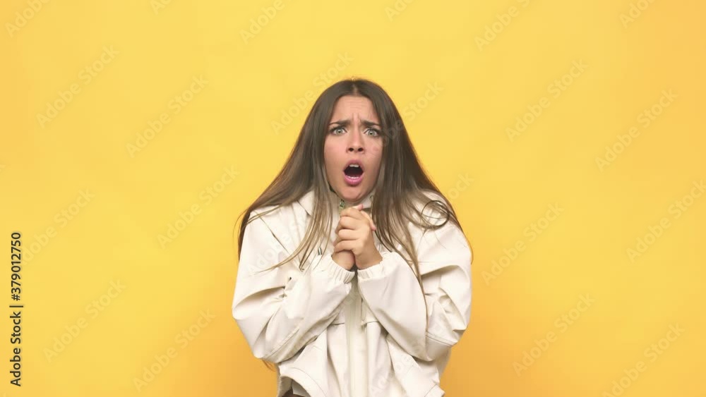 Young cute woman praying for luck, amazed and opening mouth looking to front Young cute woman praying for luck, amazed and opening mouth looking to front