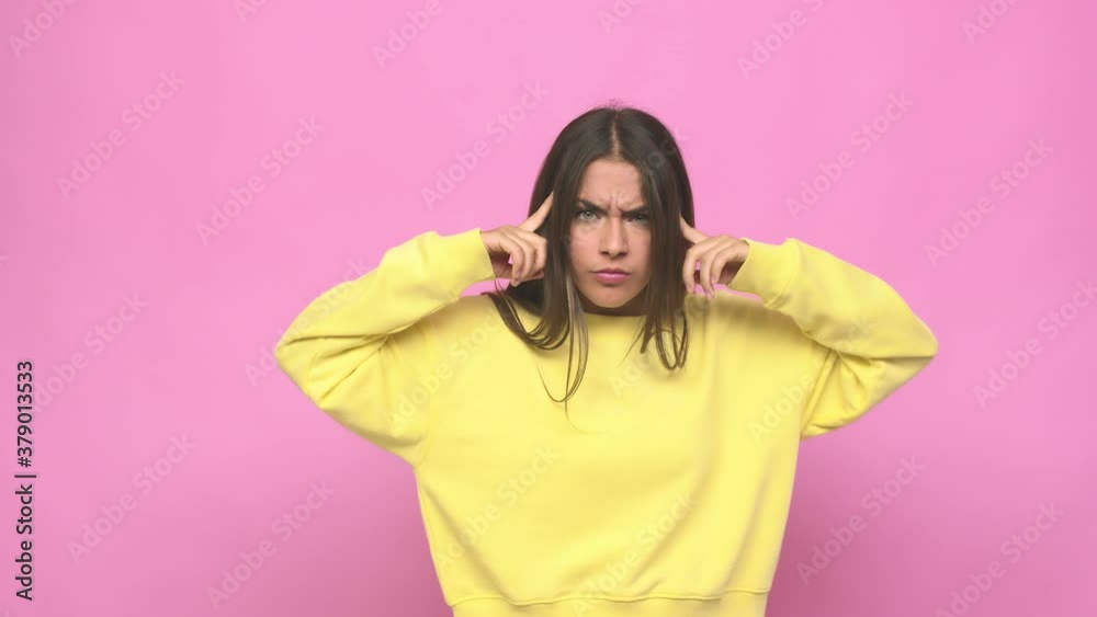 Young cute woman focused on a task, keeping forefingers pointing head Young cute woman focused on a task, keeping forefingers pointing head