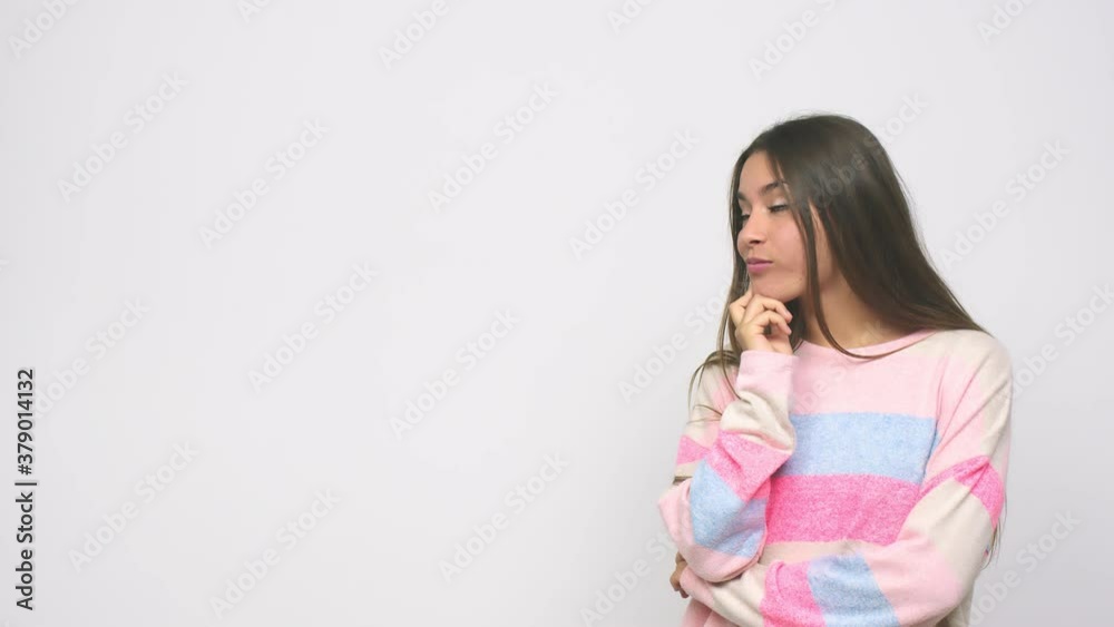 Young cute woman looking sideways with doubtful and skeptical expression