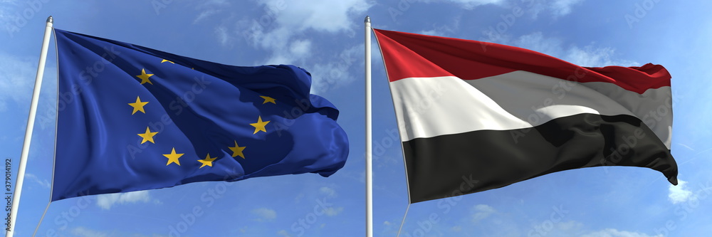 Naklejka premium Flags of the European Union and Yemen on flagpoles. 3d rendering