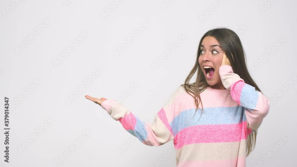 Young cute woman holds copy space on a palm, keep hand over cheek amazed and delighted Young cute woman holds copy space on a palm, keep hand over cheek amazed and delighted