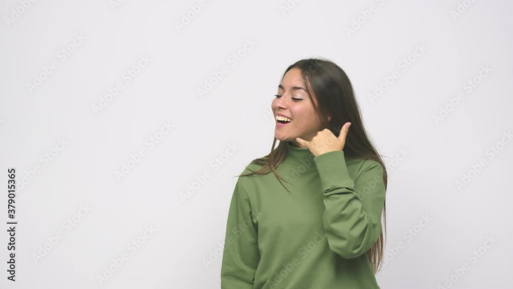 Young cute woman showing a mobile phone call gesture with fingers Young cute woman showing a mobile phone call gesture with fingers