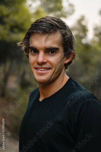 Retrato de joven atleta sonriendo, girado mirando de frente en el campo