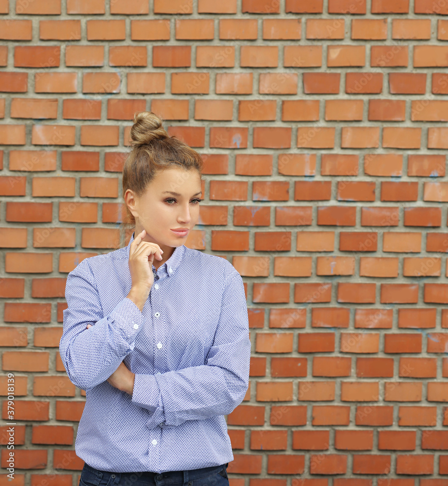 Woman standing against brick wall background.Middle aged woman portrait Woman standing against brick wall background.Middle aged woman portrait