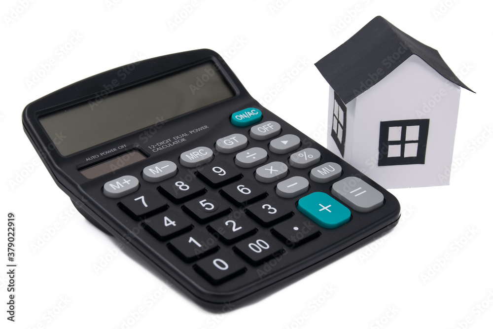 The toy house near the calculator isolated on white, mortgage calculator The toy house near the calculator isolated on white, mortgage calculator