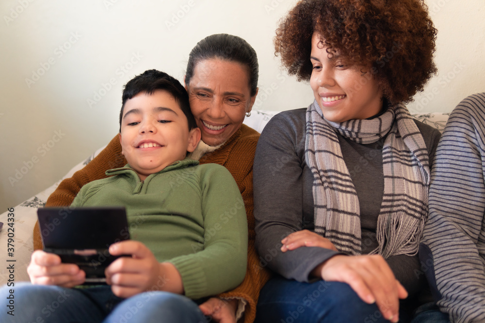 Cheerful latin young child with gamepad playing video games. Inside the house in tv living room. Relationship, leisure, enjoyment concept. Cheerful latin young child with gamepad playing video games. Inside the house in tv living room. Relationship, leisure, enjoyment concept.