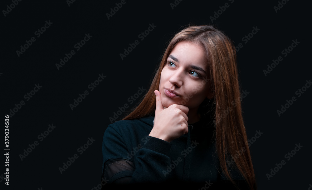 Thoughtful model in studio looking away. hand near the face