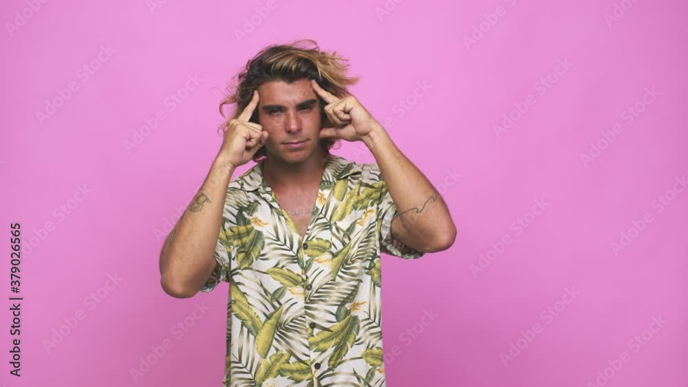 Young cool australian man focused on a task, keeping forefingers pointing head Young cool australian man focused on a task, keeping forefingers pointing head