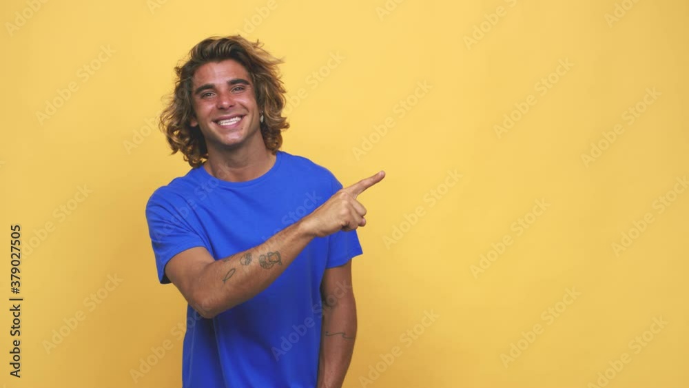 Young cool australian man smiling and pointing aside, showing something at blank space Young cool australian man smiling and pointing aside, showing something at blank space