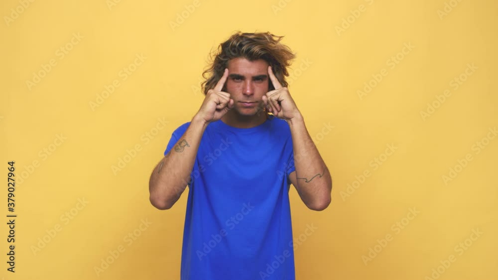 Young cool australian man focused on a task, keeping forefingers pointing head Young cool australian man focused on a task, keeping forefingers pointing head