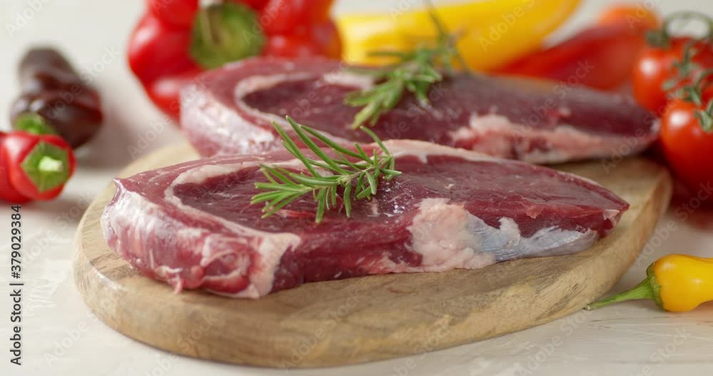 The ribeye steak raw beef with rosemary slowly rotates. The ribeye steak raw beef with rosemary slowly rotates.