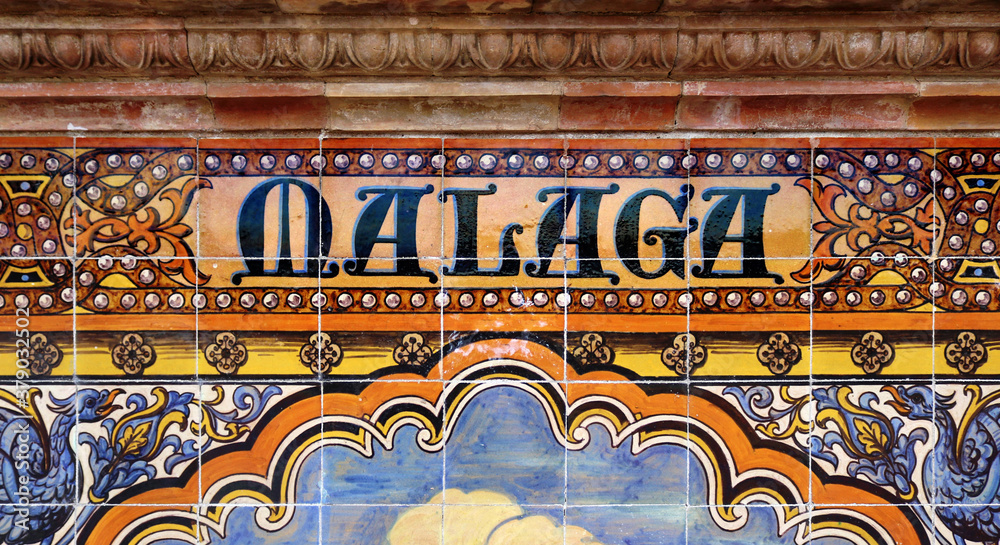 Tile with the name of the spanish city of Malaga on ceramic  with a colorful decoration located in Spain Square in Seville
