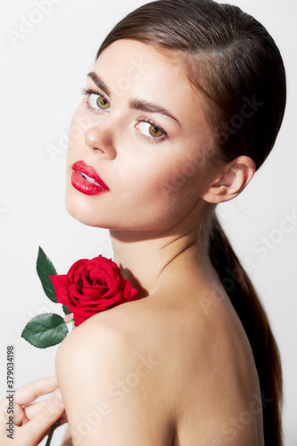 Woman with red flower Bare shoulders clean skin model red lips 