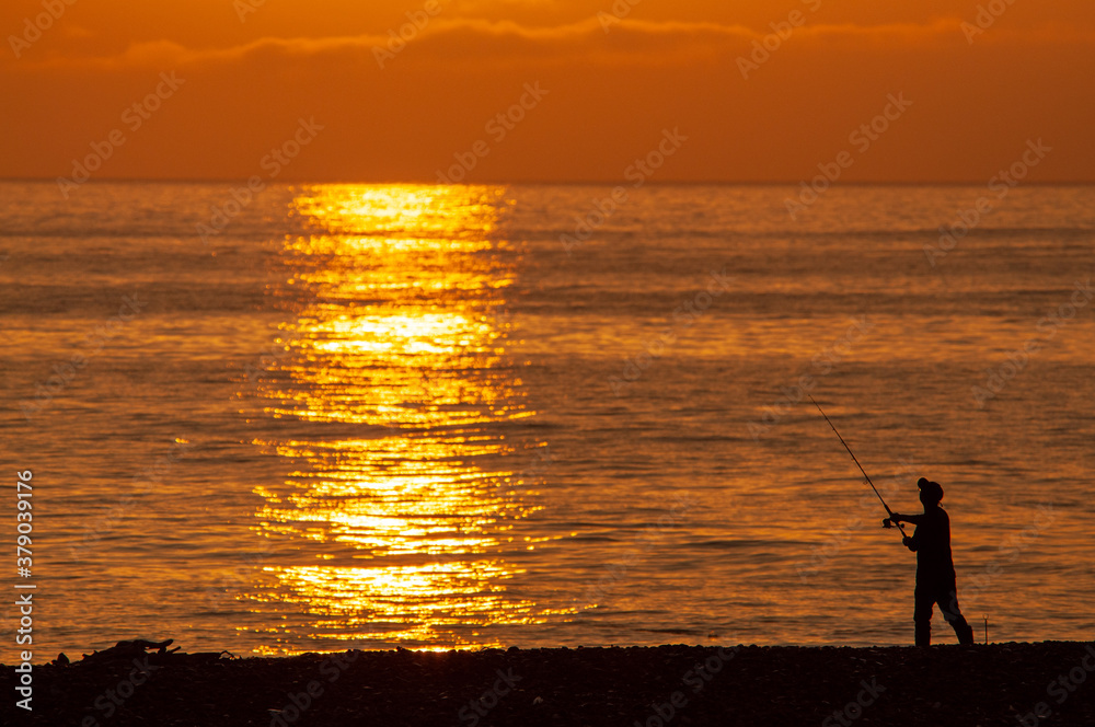 朝日を浴びている釣り人　日本　アジア