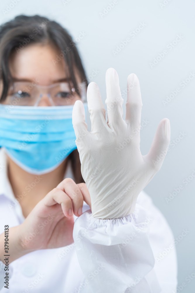 Scientist hands putting in nitrile gloves in labcoat wearing nitrile gloves Scientist hands putting in nitrile gloves in labcoat wearing nitrile gloves
